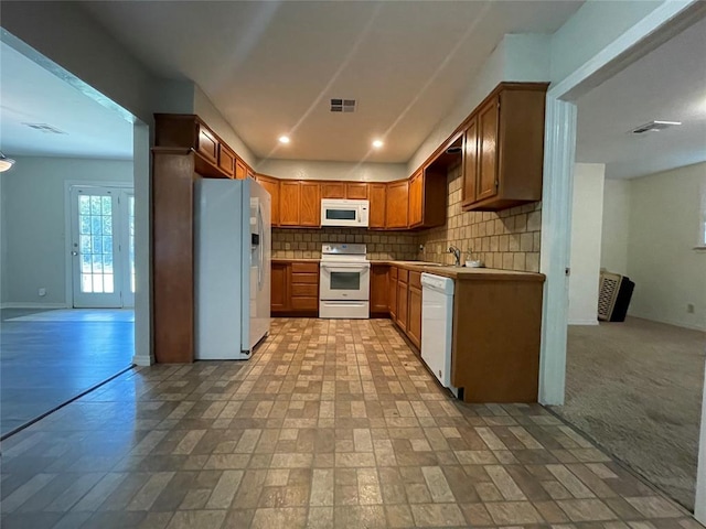 kitchen featuring sink, white appliances, light colored carpet, and backsplash