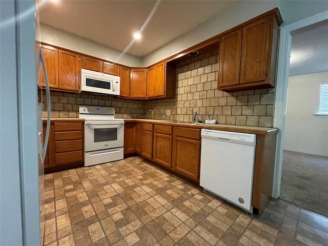 kitchen with light carpet, white appliances, sink, and backsplash