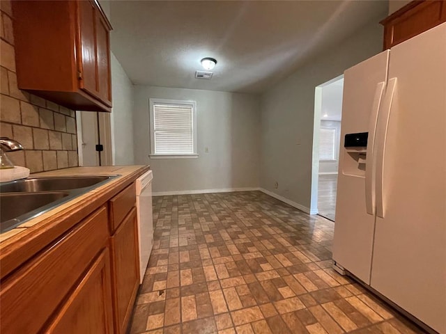 kitchen with white appliances, tasteful backsplash, and sink