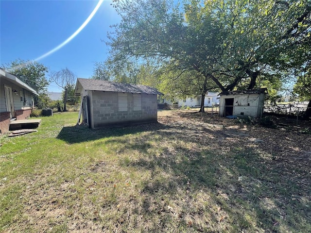 view of yard with central air condition unit and a storage unit