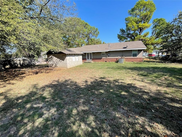 rear view of property featuring a lawn