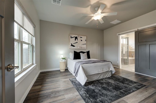 bedroom with ceiling fan, a barn door, ensuite bath, and hardwood / wood-style floors