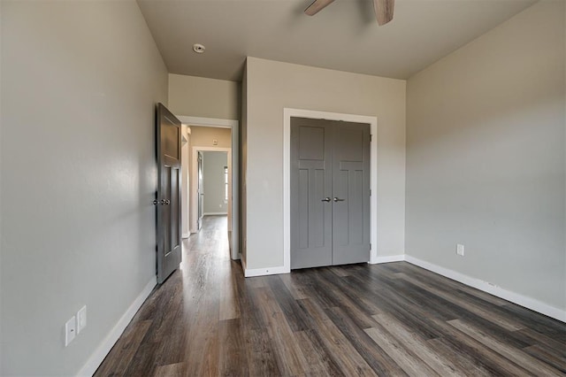 unfurnished bedroom featuring ceiling fan and dark hardwood / wood-style flooring