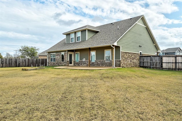 rear view of house featuring a yard and a patio