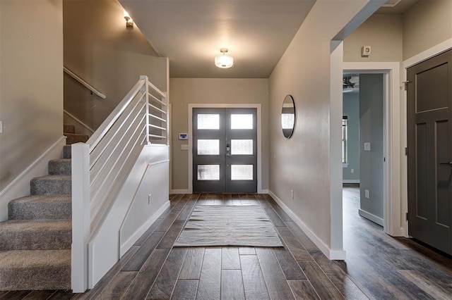 entryway featuring dark wood-style flooring, baseboards, stairway, and french doors