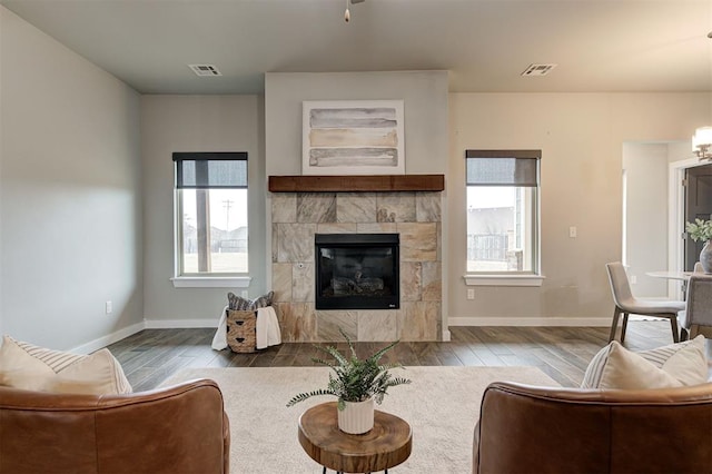 10820 Glover River Dr, Yukon, OK 73099 - living area featuring wood finished floors, plenty of natural light, a fireplace, and baseboards