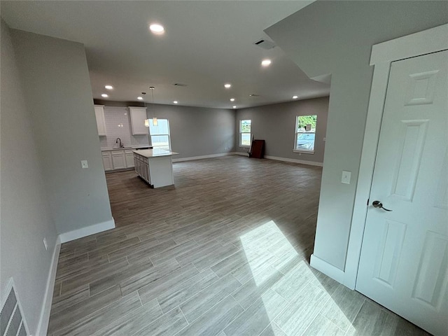 unfurnished living room featuring sink and light hardwood / wood-style flooring