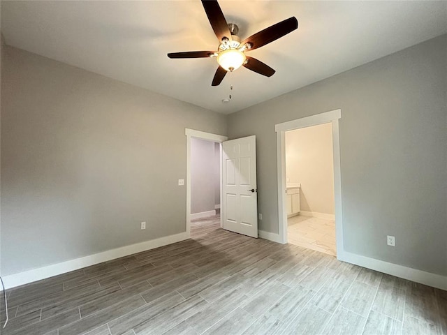 unfurnished bedroom featuring wood-type flooring, connected bathroom, and ceiling fan