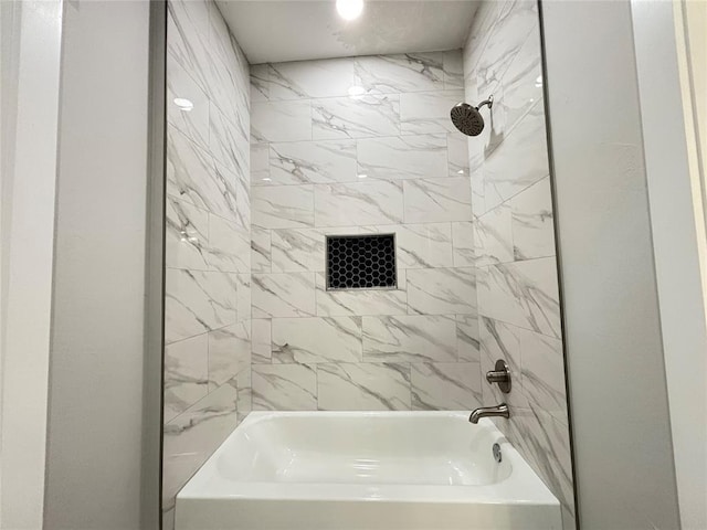 bathroom featuring tiled shower / bath