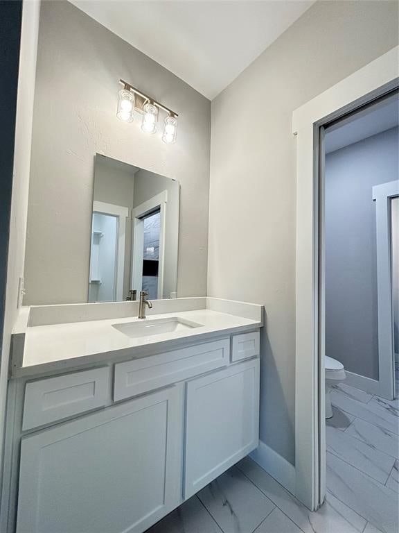 bathroom featuring vanity and toilet