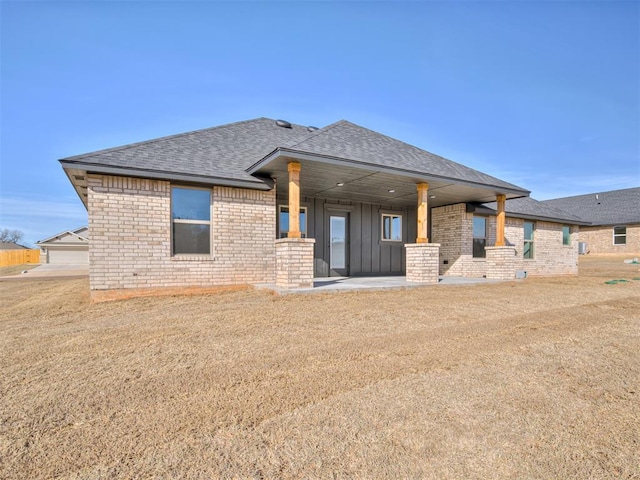 rear view of property with a lawn and a patio