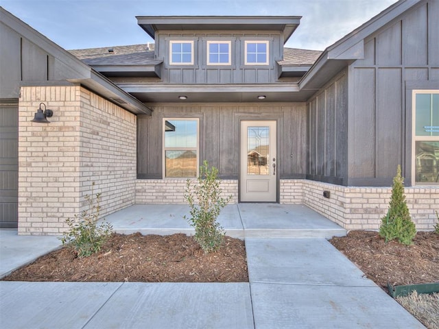 view of exterior entry with a patio