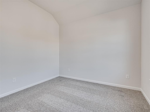 empty room featuring vaulted ceiling and carpet