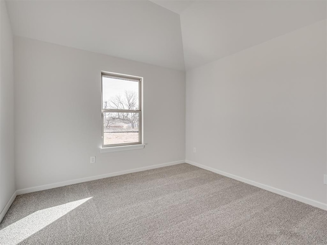 carpeted spare room featuring lofted ceiling