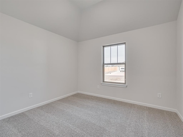 empty room featuring vaulted ceiling and carpet