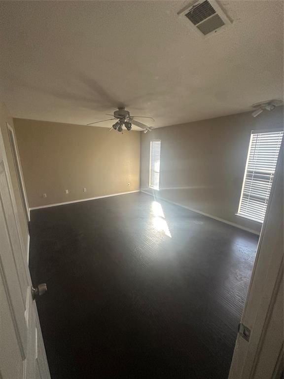 spare room with ceiling fan and dark wood-type flooring