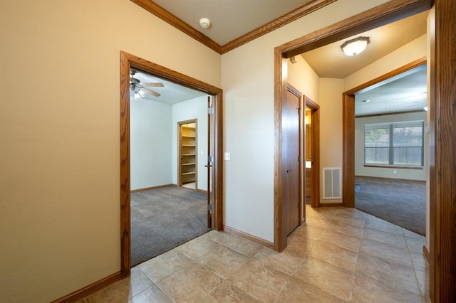 hall with light colored carpet and ornamental molding