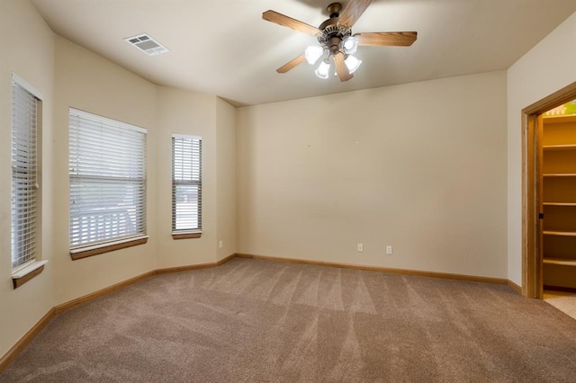 carpeted spare room featuring ceiling fan