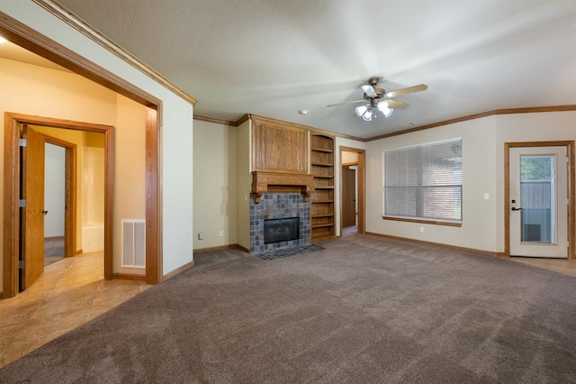 unfurnished living room featuring a tile fireplace, light carpet, ceiling fan, and ornamental molding