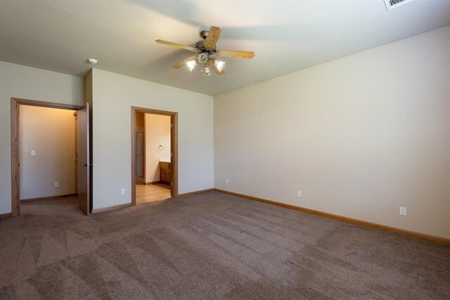 unfurnished bedroom with ceiling fan, light colored carpet, and ensuite bathroom