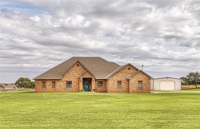 view of front facade featuring an outdoor structure, a front yard, and a garage