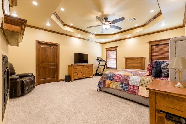 carpeted bedroom featuring a tray ceiling, ceiling fan, and crown molding