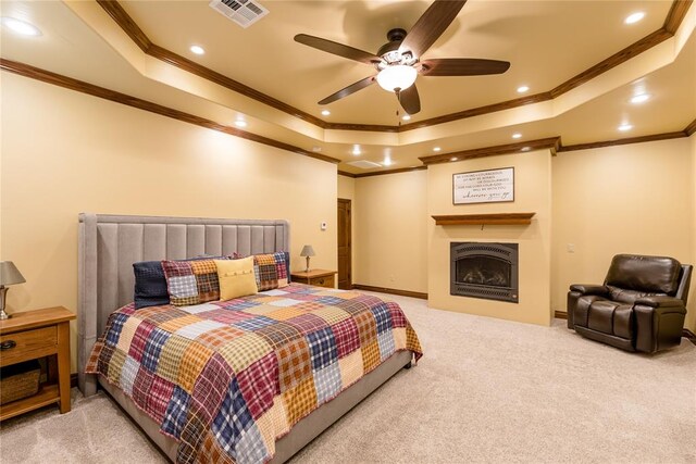 bedroom with carpet floors, a tray ceiling, ceiling fan, and crown molding