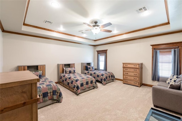 bedroom with ceiling fan, a tray ceiling, and multiple windows