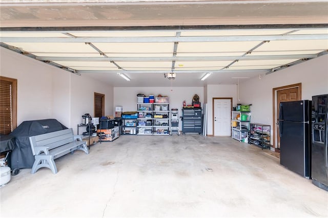 garage featuring black refrigerator and a garage door opener