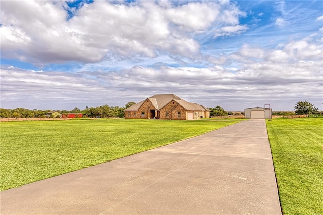 single story home with a front yard, an outbuilding, and a garage