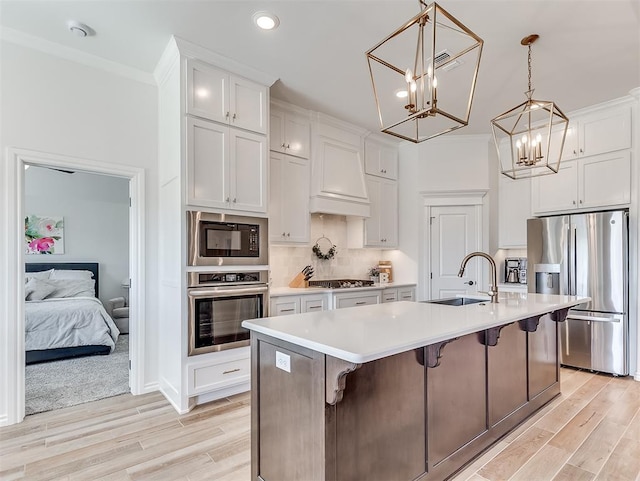 1718 Zayden Ln, Norman, OK 73072 - kitchen featuring white cabinets, sink, stainless steel appliances, and a kitchen island with sink