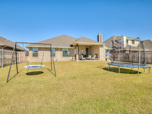 1718 Zayden Ln, Norman, OK 73072 - rear view of house with a patio area, a trampoline, and a yard