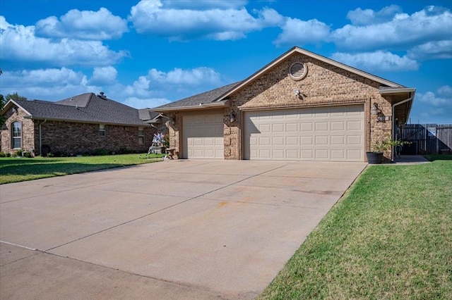 ranch-style house featuring a garage and a front lawn