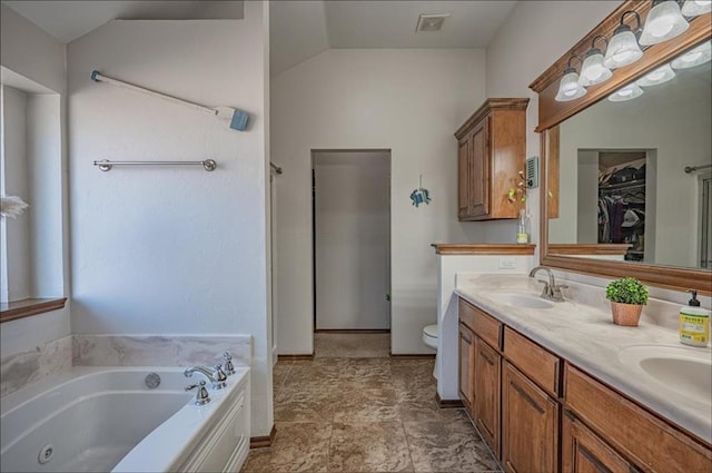 bathroom with vanity, toilet, a bath, and vaulted ceiling