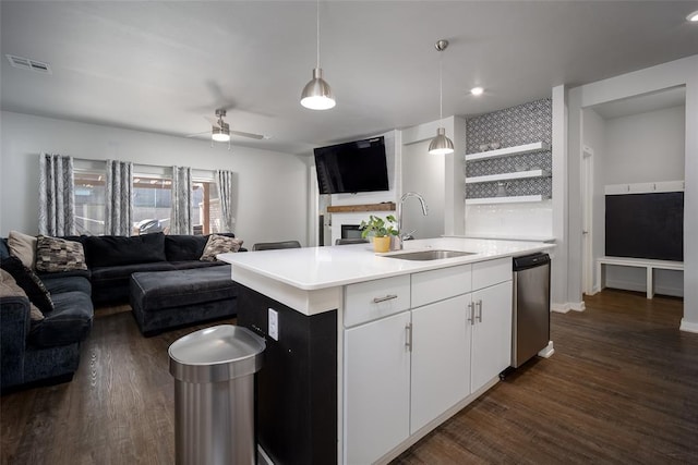 kitchen with sink, dark hardwood / wood-style floors, decorative light fixtures, a kitchen island with sink, and white cabinets