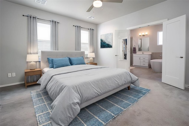 bedroom featuring ensuite bath, ceiling fan, light carpet, and multiple windows