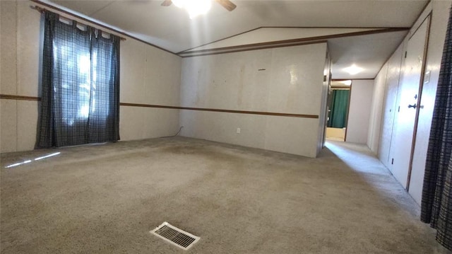 unfurnished room featuring light carpet, vaulted ceiling, and ceiling fan