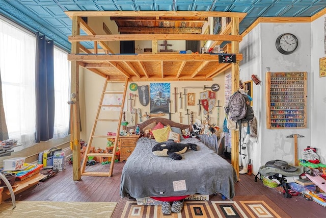 bedroom with multiple windows and dark hardwood / wood-style flooring