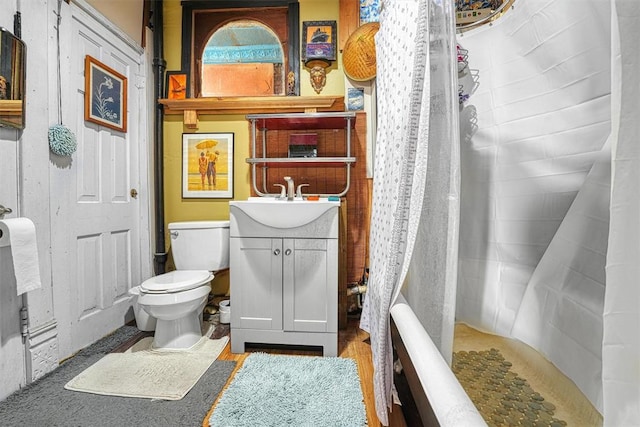 full bathroom with hardwood / wood-style floors, vanity, toilet, and shower / tub combo