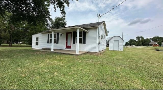 view of front of house featuring a front lawn, a porch, and a storage unit