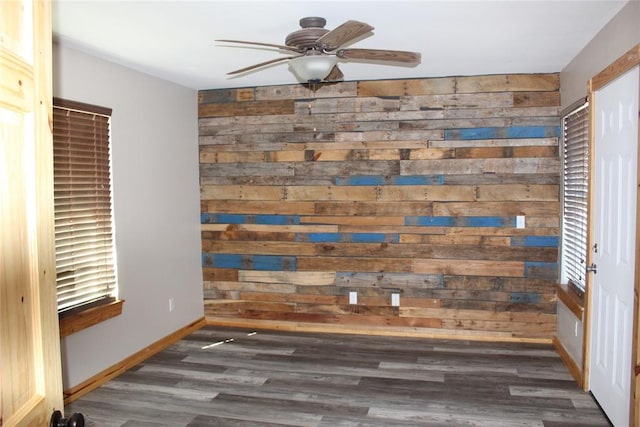 interior details with ceiling fan, hardwood / wood-style floors, and wooden walls