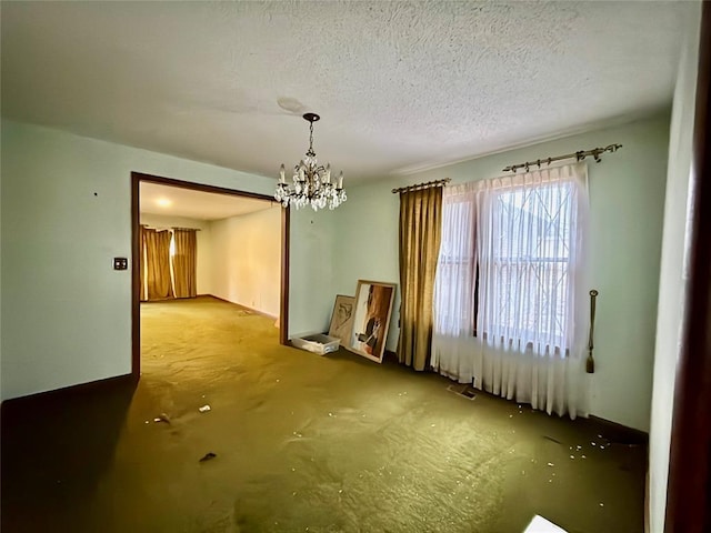 unfurnished room featuring a chandelier and a textured ceiling