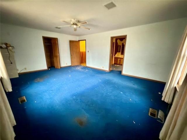 unfurnished bedroom with ceiling fan and dark carpet