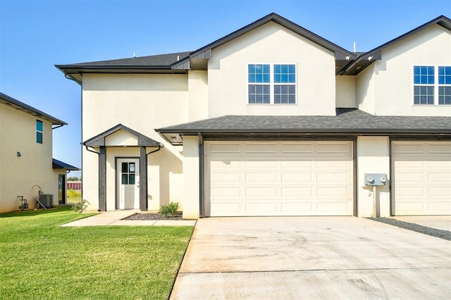 view of front of home featuring central AC, a front yard, and a garage