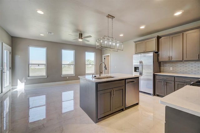 kitchen with sink, ceiling fan, an island with sink, decorative light fixtures, and stainless steel appliances