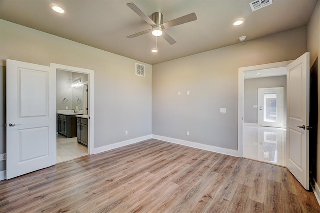 unfurnished bedroom featuring ceiling fan, light wood-type flooring, sink, and connected bathroom