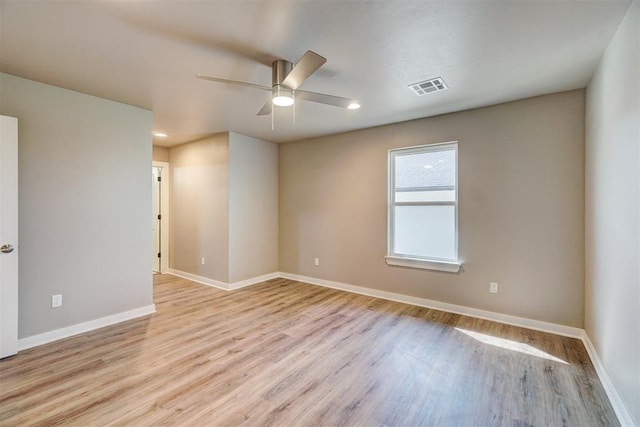 empty room with ceiling fan and light hardwood / wood-style flooring