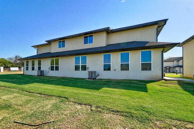 back of property featuring central AC unit and a lawn