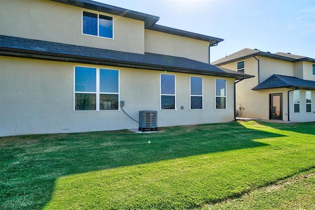 rear view of property with a lawn and central air condition unit