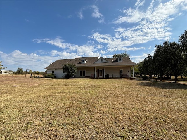 rear view of property featuring a lawn